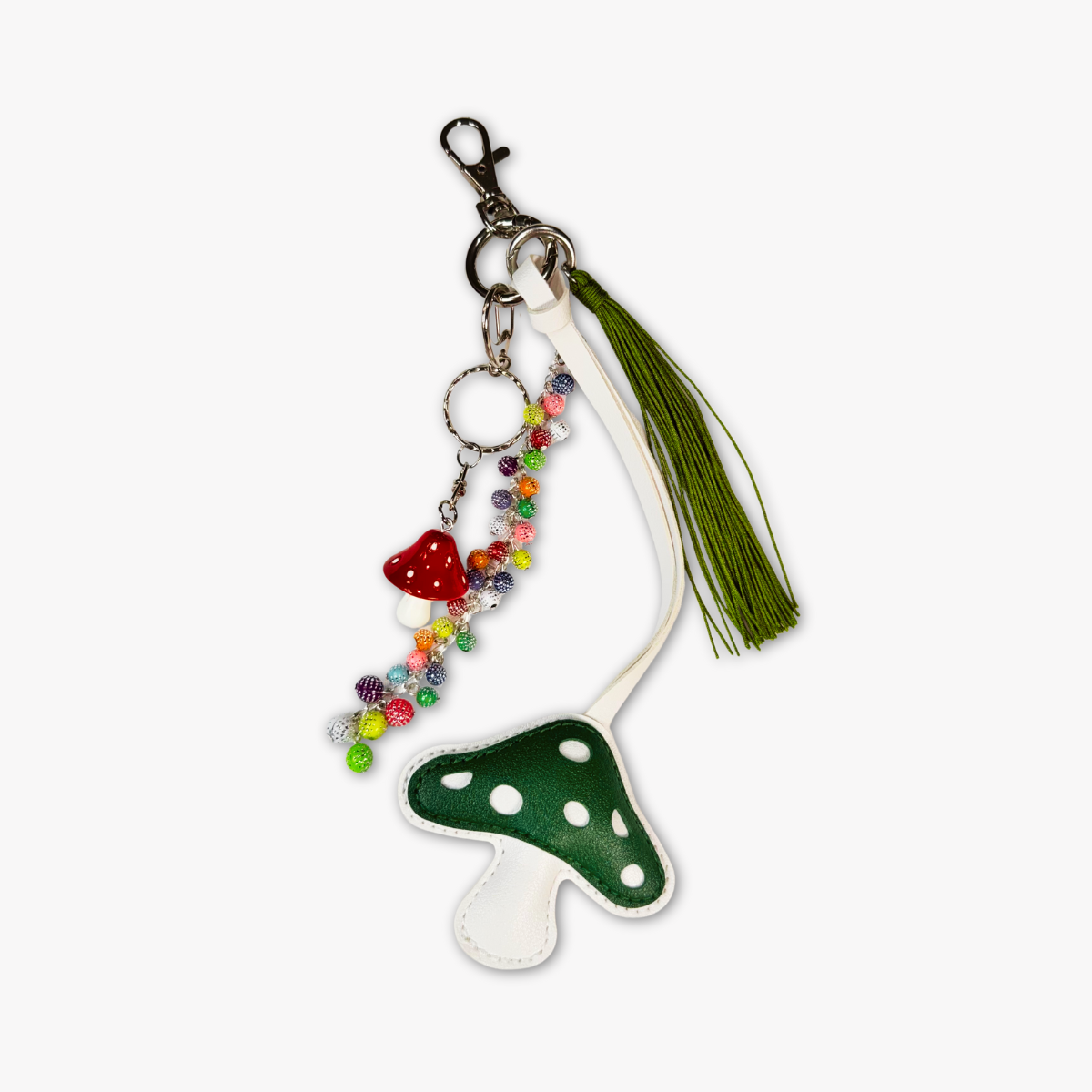 Keychain with green polka dot mushroom design and tassel on a white background
